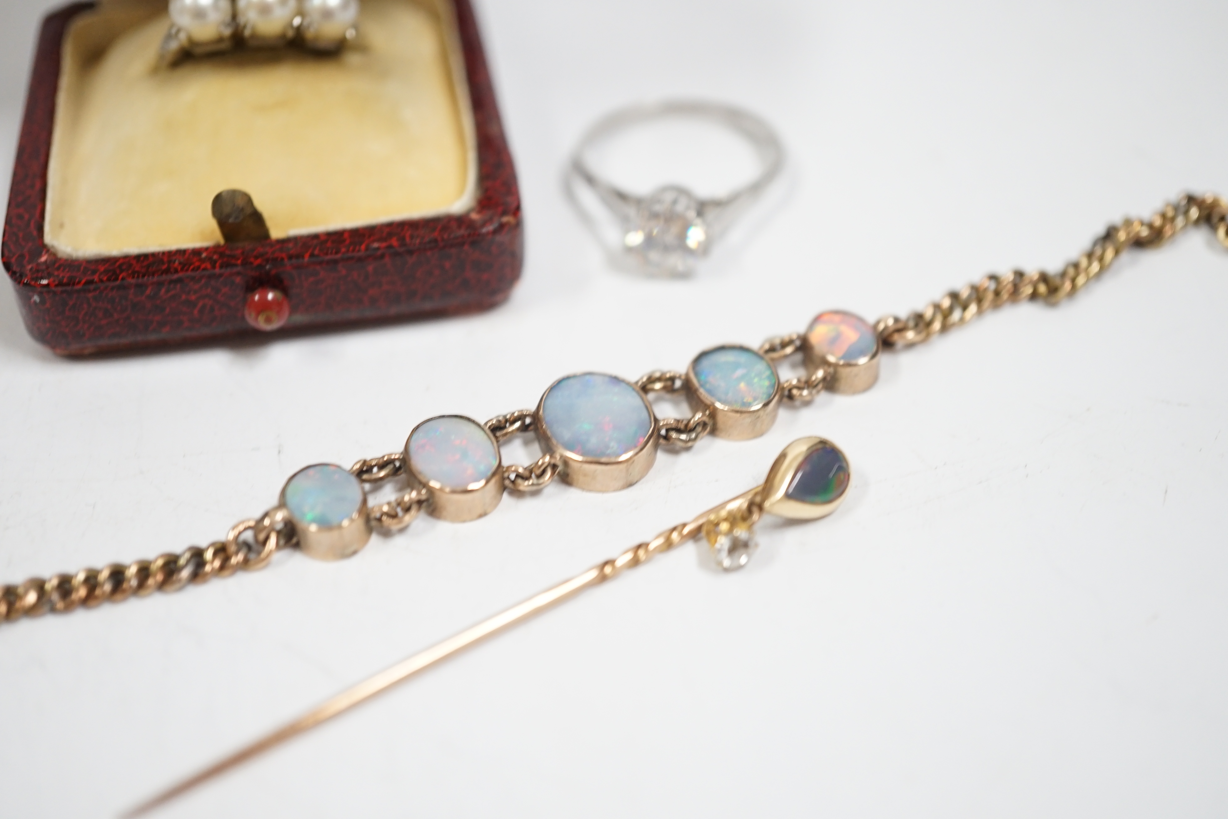 A yellow metal and graduated five stone oval white opal set bracelet, 16.5cm, a yellow metal opal and diamond drop set stick pin, a 14k white metal and three stone culture pearl set ring and a simulated diamond ring.